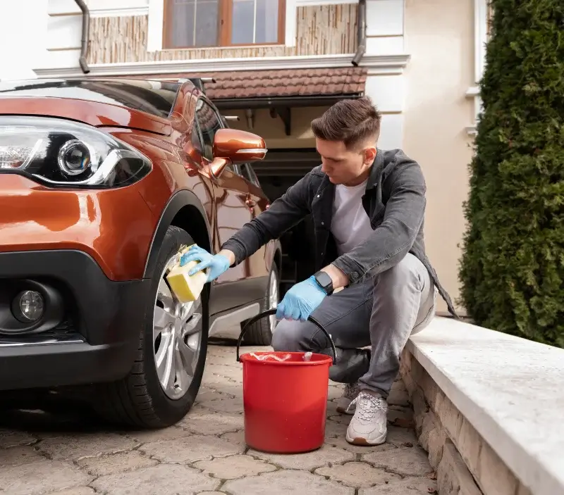Lavage auto à domicile Freix-Anglards : professionnel intervenant sur un véhicule